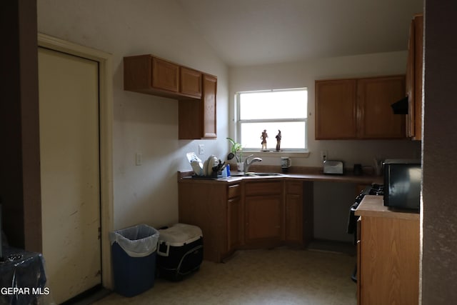 9421 Ariel Rico Ct, El Paso, TX 79907 - kitchen with brown cabinets, light floors, and vaulted ceiling