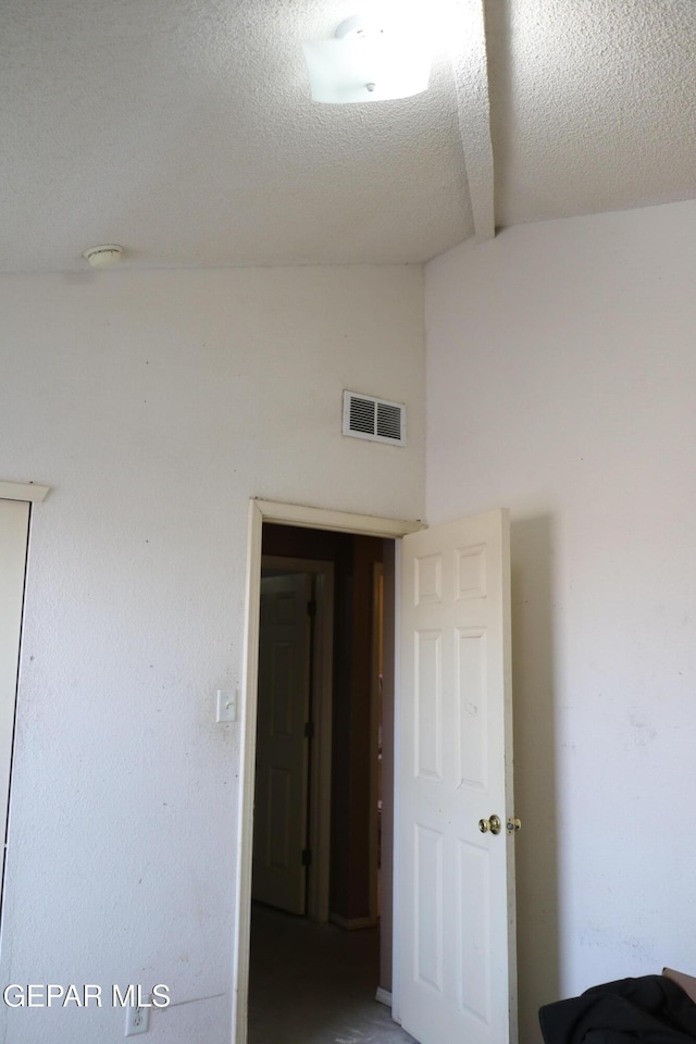 9421 Ariel Rico Ct, El Paso, TX 79907 - spare room featuring vaulted ceiling, a smoke detector, and a textured ceiling