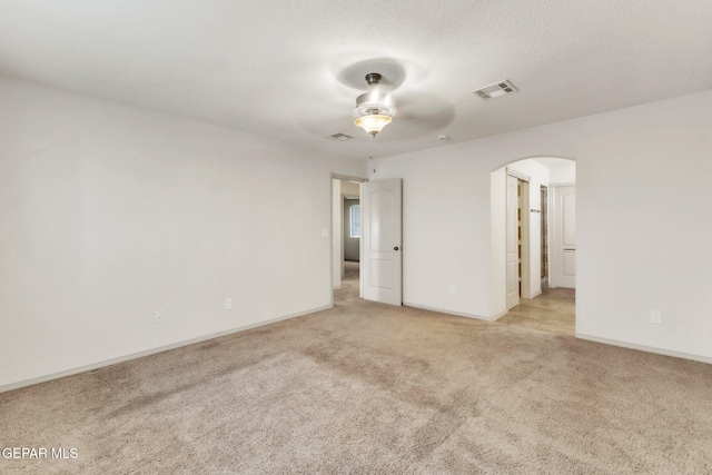 14330 Woods Point Ave, El Paso, TX 79938 - unfurnished room with light colored carpet, arched walkways, and a ceiling fan