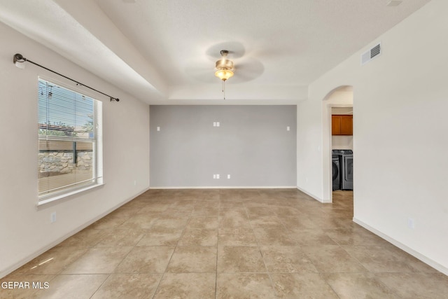 14330 Woods Point Ave, El Paso, TX 79938 - empty room featuring separate washer and dryer, ceiling fan, arched walkways, and light tile patterned floors