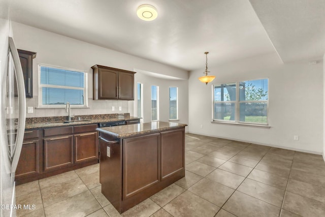 14330 Woods Point Ave, El Paso, TX 79938 - kitchen with freestanding refrigerator, a kitchen island, dark stone counters, light tile patterned floors, and dark brown cabinets