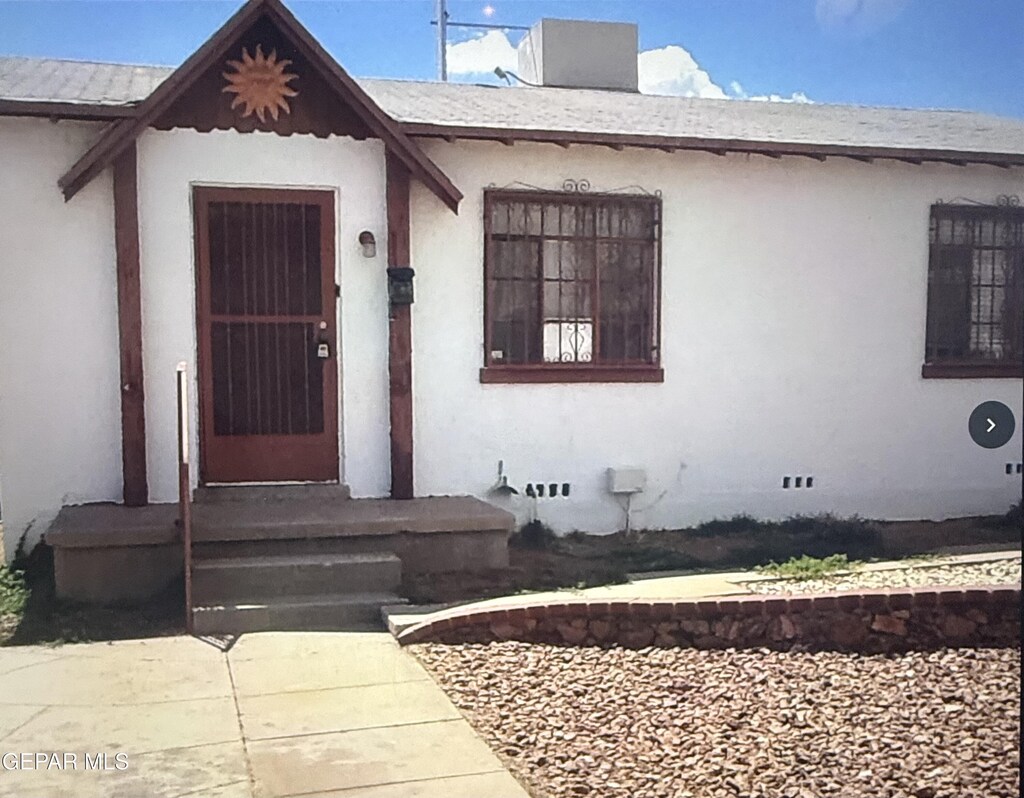 1303 Howze St, El Paso, TX 79903 - view of exterior entry featuring stucco siding and crawl space