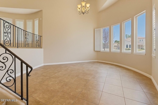 13013 Pleasant Manor Ct, El Paso, TX 79938 - spare room featuring tile patterned flooring, a chandelier, stairway, and a high ceiling