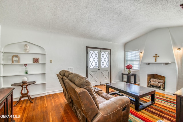 4327 Oxford Ave, El Paso, TX 79903 - living room featuring a textured ceiling, hardwood / wood-style floors, and vaulted ceiling