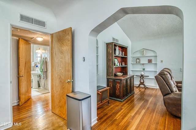 4327 Oxford Ave, El Paso, TX 79903 - office featuring wood-type flooring, built in features, a textured ceiling, lofted ceiling, and arched walkways