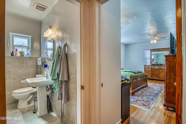 4327 Oxford Ave, El Paso, TX 79903 - bathroom with tile walls, wood finished floors, ceiling fan, and a wainscoted wall