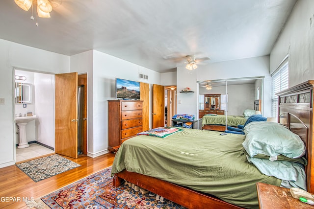 4327 Oxford Ave, El Paso, TX 79903 - bedroom with light wood-style flooring, ceiling fan, a closet, ensuite bathroom, and a fireplace