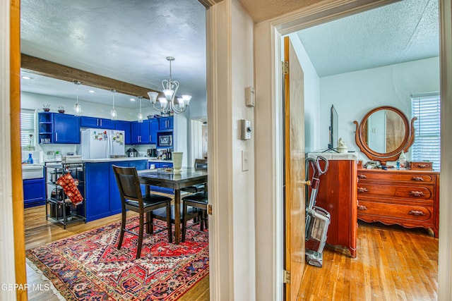 4327 Oxford Ave, El Paso, TX 79903 - dining space with a chandelier, a textured ceiling, light wood finished floors, and beam ceiling