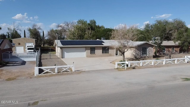 8429 Lasso Cir, El Paso, TX 79907 - view of front facade featuring roof mounted solar panels, driveway, a garage, and a gate