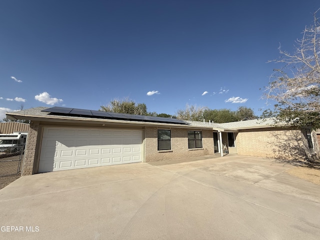 8429 Lasso Cir, El Paso, TX 79907 - single story home with brick siding, a garage, roof mounted solar panels, and concrete driveway