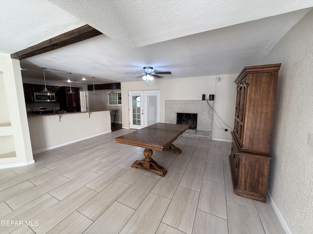 8429 Lasso Cir, El Paso, TX 79907 - living room featuring a ceiling fan, a textured ceiling, a fireplace, french doors, and a textured wall