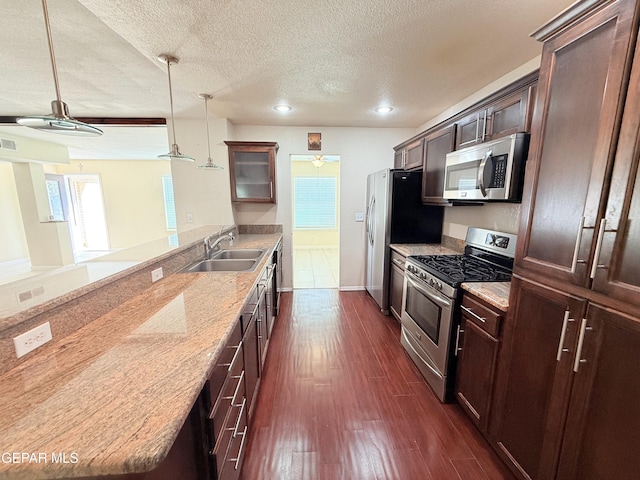 8429 Lasso Cir, El Paso, TX 79907 - kitchen featuring stainless steel appliances, a textured ceiling, dark wood-type flooring, dark brown cabinets, and a peninsula