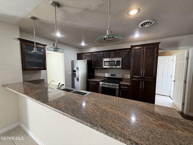 8429 Lasso Cir, El Paso, TX 79907 - kitchen with stainless steel appliances, dark brown cabinets, dark stone counters, light tile patterned flooring, and a textured ceiling