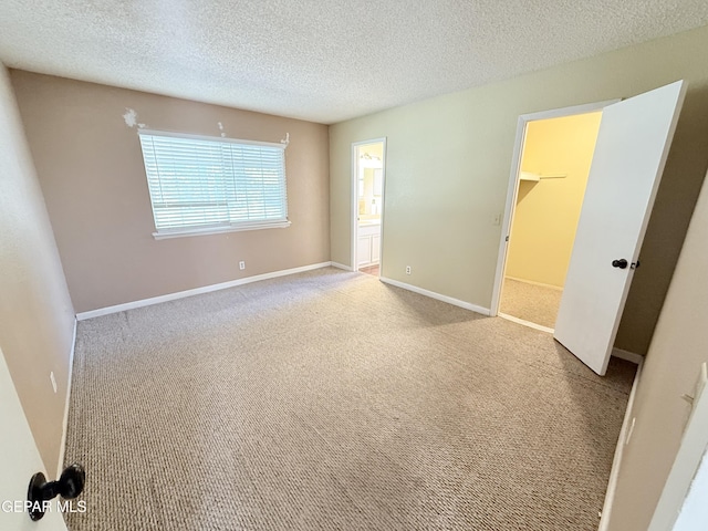 8429 Lasso Cir, El Paso, TX 79907 - unfurnished bedroom featuring carpet flooring, a textured ceiling, and ensuite bathroom