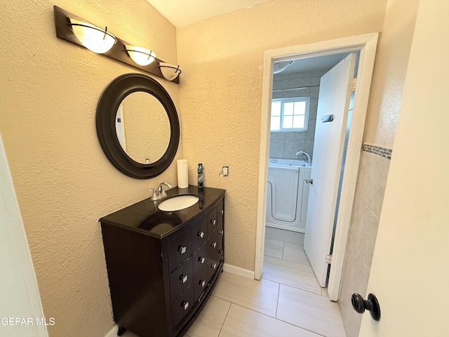 8429 Lasso Cir, El Paso, TX 79907 - full bathroom with vanity, a bath, tile patterned floors, and a textured wall