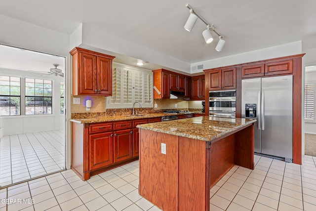 745 Rinconada Ln, El Paso, TX 79932 - kitchen featuring appliances with stainless steel finishes, light tile patterned flooring, a kitchen island, and tasteful backsplash