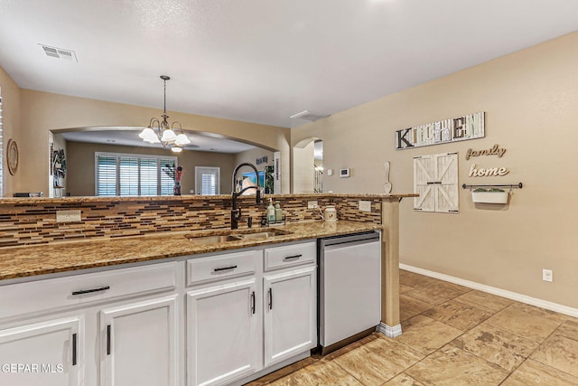 448 White Cloud Rd, El Paso, TX 79928 - kitchen with dishwasher, backsplash, arched walkways, white cabinetry, and decorative light fixtures