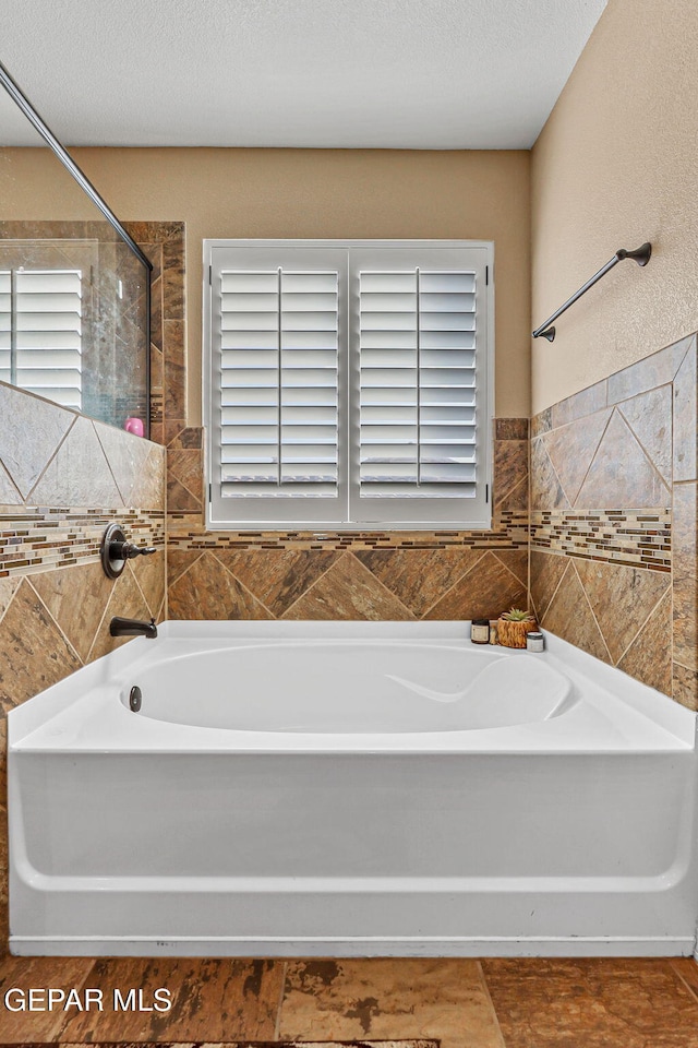 448 White Cloud Rd, El Paso, TX 79928 - full bath with healthy amount of natural light, a bath, a shower, and tile walls
