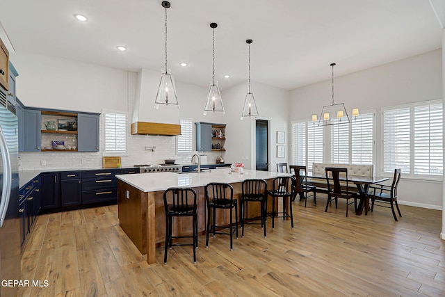 6328 Camino Nogal Dr, El Paso, TX 79932 - kitchen with open shelves, light wood-type flooring, tasteful backsplash, a chandelier, and light countertops