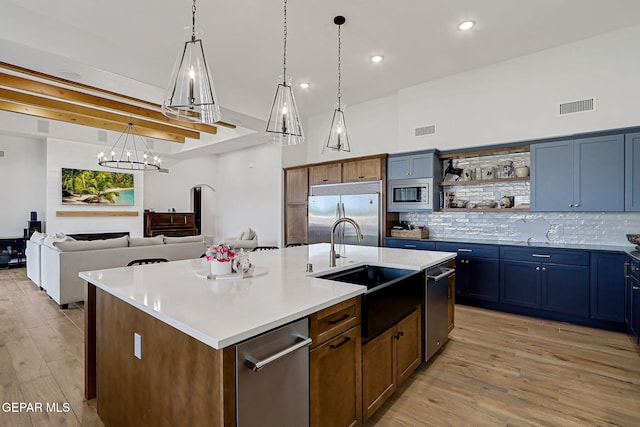 6328 Camino Nogal Dr, El Paso, TX 79932 - kitchen featuring built in appliances, a chandelier, light wood-style floors, backsplash, and a kitchen island with sink