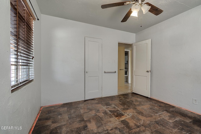 301 Cooley Ave, El Paso, TX 79907 - unfurnished bedroom featuring stone finish floors and a ceiling fan