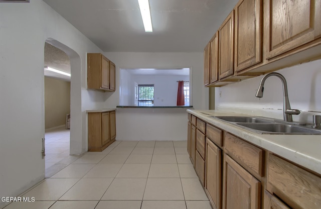 301 Cooley Ave, El Paso, TX 79907 - kitchen featuring light tile patterned floors, light countertops, and brown cabinetry