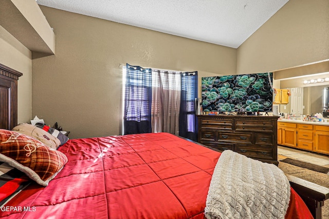 4728 Loma Grande Dr, El Paso, TX 79934 - bedroom featuring a textured wall, ensuite bath, vaulted ceiling, and a textured ceiling