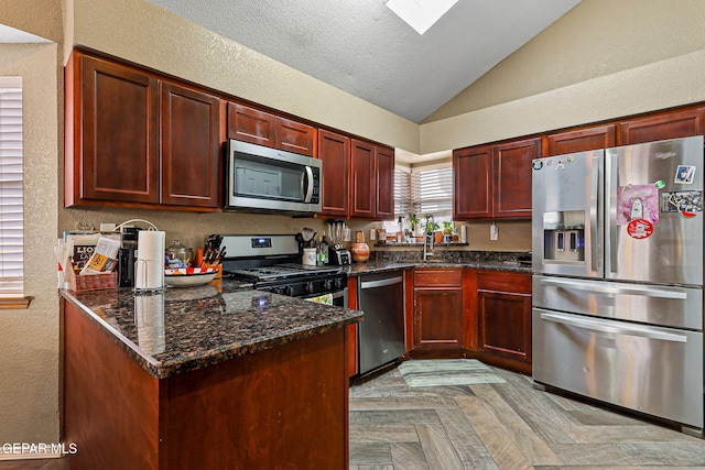 4728 Loma Grande Dr, El Paso, TX 79934 - kitchen with appliances with stainless steel finishes, lofted ceiling, dark brown cabinets, a textured wall, and dark stone counters