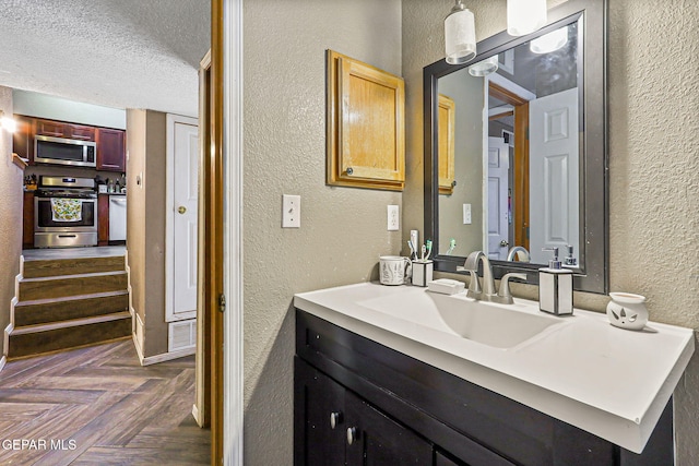 4728 Loma Grande Dr, El Paso, TX 79934 - bathroom with a textured wall, vanity, and a textured ceiling