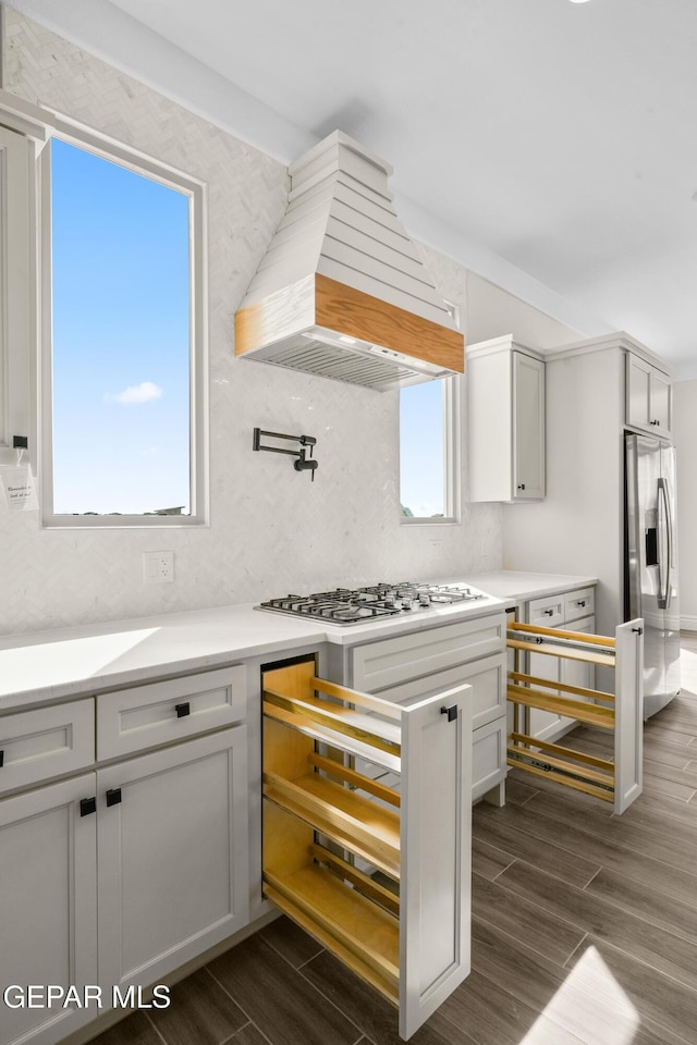 13375 Jeff Winton Dr, El Paso, TX 79928 - kitchen featuring custom range hood, stainless steel appliances, dark wood-type flooring, decorative backsplash, and light countertops