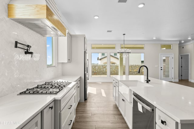 13375 Jeff Winton Dr, El Paso, TX 79928 - kitchen featuring appliances with stainless steel finishes, premium range hood, recessed lighting, wood finished floors, and a center island with sink