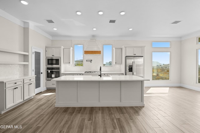 13375 Jeff Winton Dr, El Paso, TX 79928 - kitchen featuring appliances with stainless steel finishes, a kitchen island with sink, light countertops, light wood finished floors, and recessed lighting