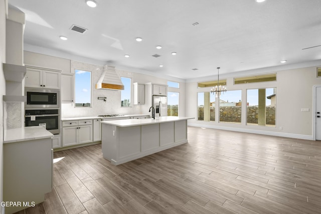 13375 Jeff Winton Dr, El Paso, TX 79928 - kitchen featuring appliances with stainless steel finishes, plenty of natural light, light countertops, custom exhaust hood, and recessed lighting