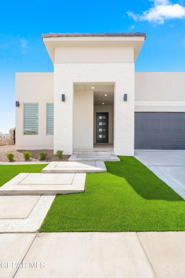 13375 Jeff Winton Dr, El Paso, TX 79928 - entrance to property with a garage, concrete driveway, brick siding, and a yard