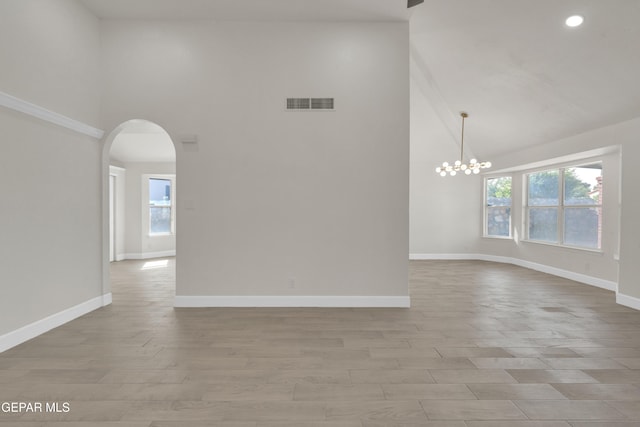 4321 Loma Casitas Rd, El Paso, TX 79934 - unfurnished room featuring high vaulted ceiling, arched walkways, healthy amount of natural light, a chandelier, and light wood-type flooring