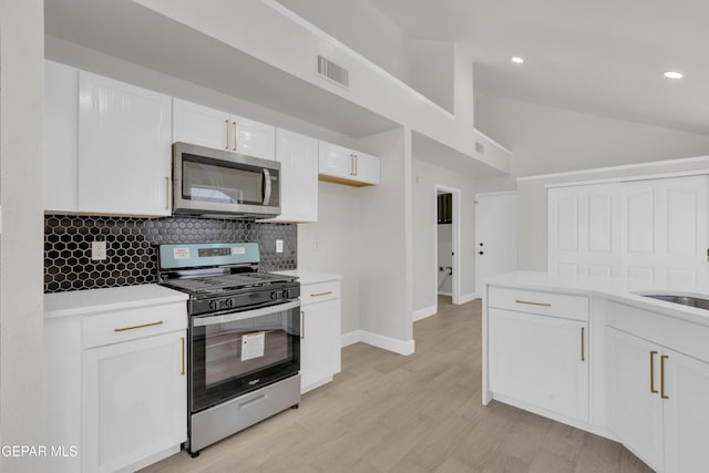 4321 Loma Casitas Rd, El Paso, TX 79934 - kitchen with stainless steel appliances, vaulted ceiling, backsplash, white cabinets, and light countertops