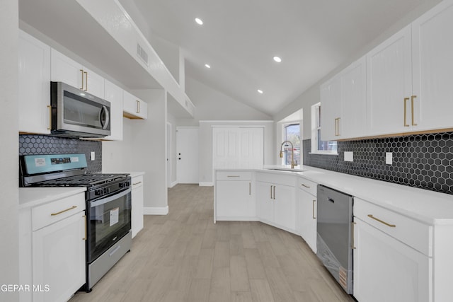 4321 Loma Casitas Rd, El Paso, TX 79934 - kitchen featuring stainless steel appliances, a peninsula, tasteful backsplash, white cabinetry, and lofted ceiling