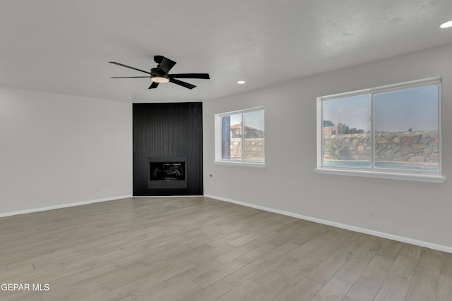 4321 Loma Casitas Rd, El Paso, TX 79934 - unfurnished living room with light wood-type flooring, a ceiling fan, recessed lighting, and a fireplace