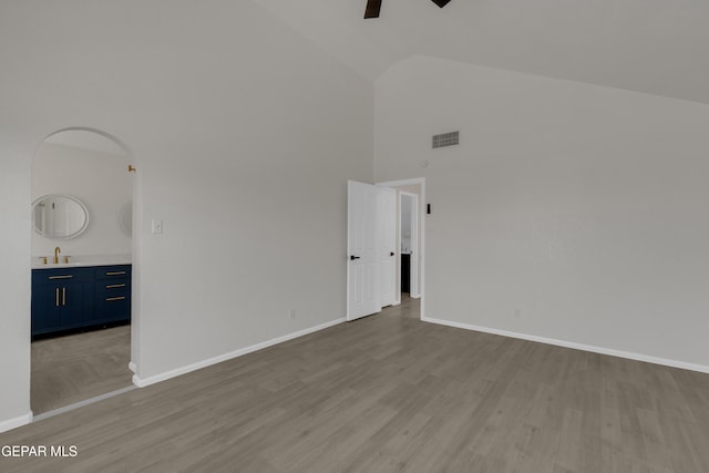 4321 Loma Casitas Rd, El Paso, TX 79934 - unfurnished room featuring high vaulted ceiling, ceiling fan, wood finished floors, and arched walkways