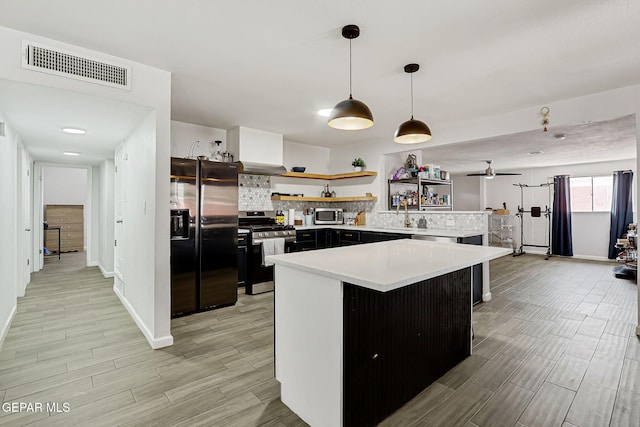 9128 Diana Dr, El Paso, TX 79924 - kitchen featuring appliances with stainless steel finishes, open shelves, wood tiled floors, and light countertops