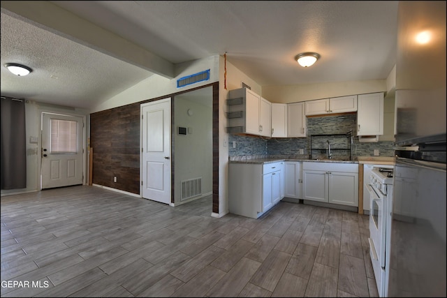 5726 Dearborne Dr, El Paso, TX 79924 - kitchen with white cabinetry, wood finished floors, a textured ceiling, tasteful backsplash, and white range with gas stovetop