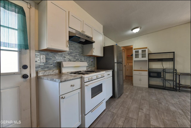 5726 Dearborne Dr, El Paso, TX 79924 - kitchen featuring under cabinet range hood, white range with gas stovetop, healthy amount of natural light, and decorative backsplash