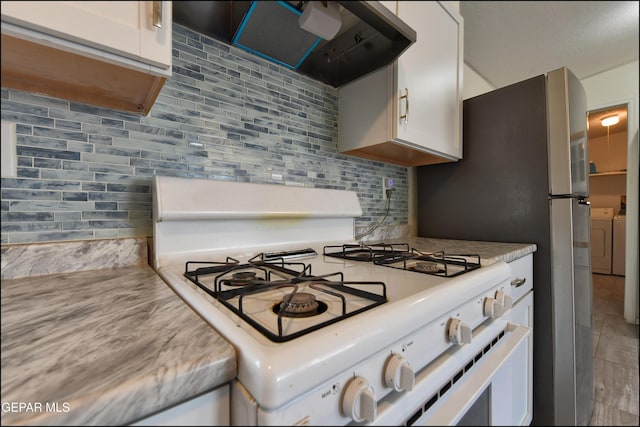 5726 Dearborne Dr, El Paso, TX 79924 - kitchen with white gas range oven, range hood, decorative backsplash, light countertops, and white cabinetry