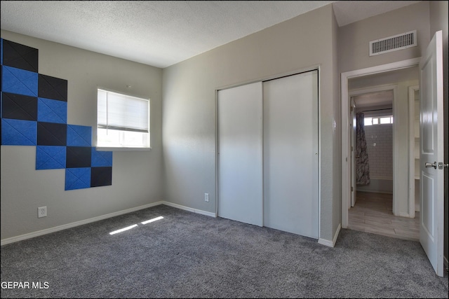 5726 Dearborne Dr, El Paso, TX 79924 - unfurnished bedroom with multiple windows, carpet, a closet, and a textured ceiling