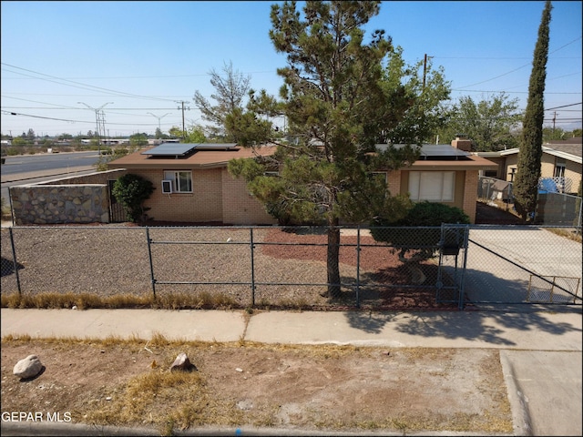 5726 Dearborne Dr, El Paso, TX 79924 - view of front of property featuring brick siding, roof mounted solar panels, and a fenced front yard