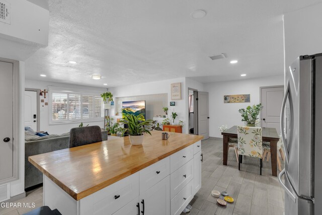 8142 Cook Dr, El Paso, TX 79907 - kitchen featuring freestanding refrigerator, butcher block counters, white cabinets, recessed lighting, and a kitchen island