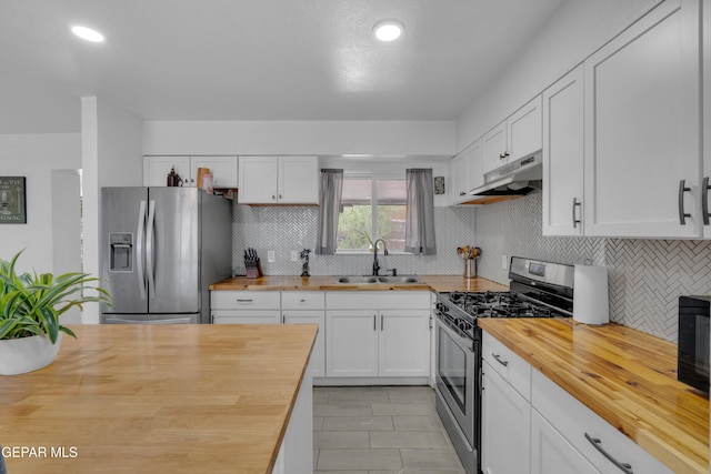 8142 Cook Dr, El Paso, TX 79907 - kitchen featuring butcher block counters, appliances with stainless steel finishes, under cabinet range hood, backsplash, and white cabinets