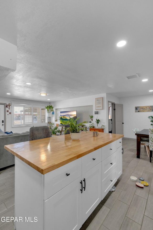 8142 Cook Dr, El Paso, TX 79907 - kitchen featuring wooden counters, white cabinets, recessed lighting, wood tiled floors, and open floor plan