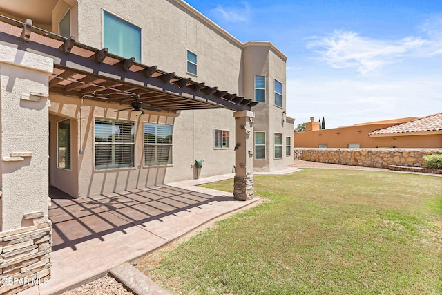 6310 Franklin Crest Dr, El Paso, TX 79912 - back of house featuring stucco siding, a pergola, a lawn, a ceiling fan, and a patio