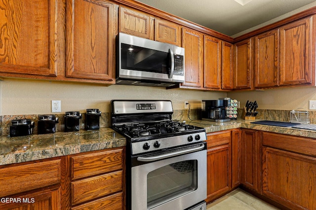 6310 Franklin Crest Dr, El Paso, TX 79912 - kitchen with stainless steel appliances, tile counters, and brown cabinets